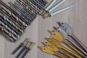 Diferentes herramientas en un fondo de madera. taladro, taladro para madera, broca para hormigón foto
