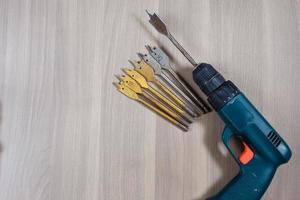 Different tools on a wooden background. drill, Wood drill, concrete drill bit photo