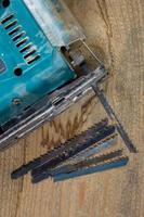 Different tools on a wooden background. Electric jigsaw and saws photo