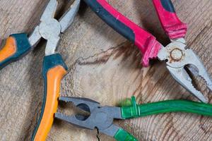 Different tools on a wooden background, pliers photo