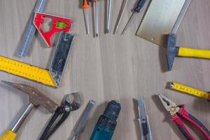 Different tools on a wooden background. Hammer, drill, pliers. Screwdriver, ruler, cutting pliers photo