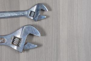 Different tools on a wooden background. Adjustable wrench photo