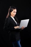 Business woman hold notebook computer and shopping online with internet financial banking. Technology help person working communicate every where on mobile phone or laptop, black background photo