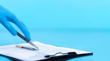 Operation being performed by a doctor while a Patient relative signs a document agreement with consent. scalpel blade used as a pen for lawyer legal documents insurance and protection, copy space photo