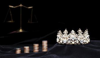 corona de diamantes del concurso de concurso de reina de belleza miss y mazo de equilibrio de justicia de escala con inversión de dinero de moneda de pila. concepto de equidad e injusticia en el negocio de concursos de concursos, espacio de copia foto