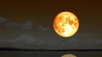 el reflejo de la superluna de sangre vuelve a subir silueta paisaje lago en el cielo nocturno y el fondo de nubes oscuras en movimiento lapso de tiempo video