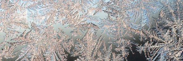 Snowflakes frost rime macro on window glass pane photo