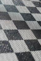 Plastic texture in the form of a very small cloth binding, painted in black and gray in the style of a chessboard. Macro shot photo