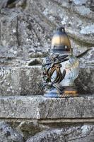 A metal lamp stands on the stone surface of an old crypt photo