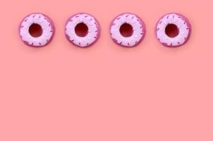 Many small plastic donuts lies on a pastel colorful background. Flat lay minimal pattern. Top view photo