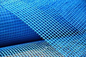 Close-up texture of a blue reinforcing mesh rolled up in a roll. Building resource for reinforcing walls in the process of their warming photo