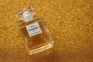 TERNOPIL, UKRAINE - SEPTEMBER 2, 2022 Chanel Number 5 Eau Premiere worldwide famous french perfume bottle on shiny glitter background in purple colors