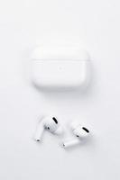 KHARKIV, UKRAINE - JANUARY 27, 2021 Apple AirPods Pro on a white background. Wireless headphones with charging case and a box. Apple Inc. is an American technology company photo