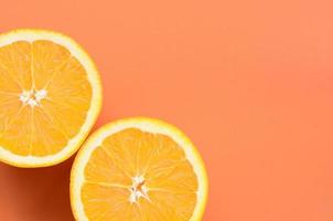 Top view of a several orange fruit slices on bright background in orange color. A saturated citrus texture image photo