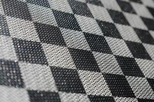 textura plástica en forma de encuadernación de tela muy pequeña, pintada en negro y gris al estilo de un tablero de ajedrez. tiro macro foto