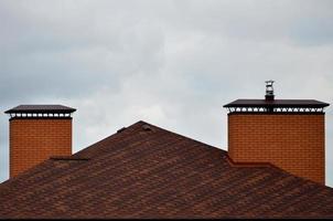 The house is equipped with high-quality roofing of shingles bitumen tiles. A good example of perfect roofing. The roof is reliably protected from adverse weather conditions photo