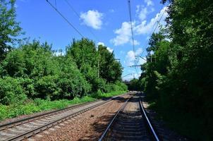 paisaje verde de verano con vías de tren y cielo azul foto