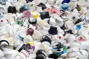 A pattern of many used and soiled nozzles from spray cans with aerosol paint. Background texture of the street art of drawing graffiti on the walls photo