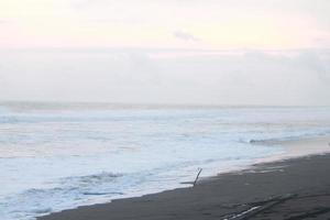 photo of beach scenery on a sunny day, visible beach sand and coastal waters