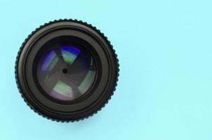 Camera lens with a closed aperture lie on texture background of fashion pastel blue color paper photo