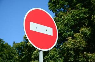 un cartel rojo circular con una barra blanca que indica que no hay entrada en un poste de metal gris foto