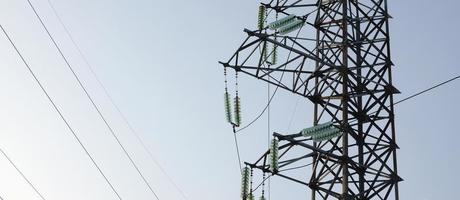 torre de líneas eléctricas contra el cielo azul foto