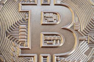 Close up shot of a physical bitcoin with a shiny relief surface made of chocolate. Abstract image of the crypto currency in an edible form photo