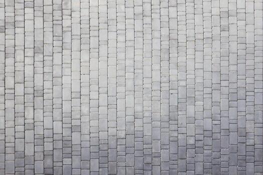 Gray color paving slabs in the pedestrian street sidewalk. Rough cobblestone pattern with many square shaped stones photo
