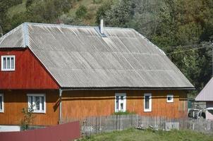 The texture of the roof with shiver slate coating. Rough and old roof of gray slate wavy sheets. Waterproof roofing from asbestos material photo