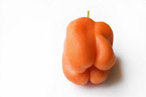 Orange large pepper fruit on a white background. Beautiful ripe pepper close-up. photo