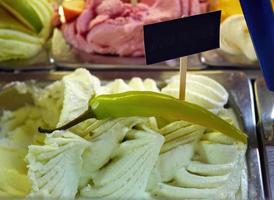 Close up Bell Pepper flavored and other flavors of gelato ice cream at the showcase in homemade ice cream shop photo