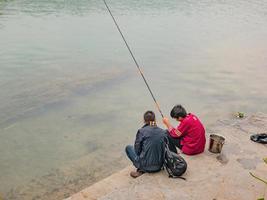 fenghuang,hunan.china-16 de octubre de 2018.personas locales chinas desconocidas pescando en el río del casco antiguo de fenghuang.la ciudad antigua de phoenix o el condado de fenghuang es un condado de la provincia de hunan, china foto