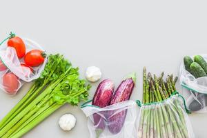 Fresh vegetables in reusable produce shopping bags photo