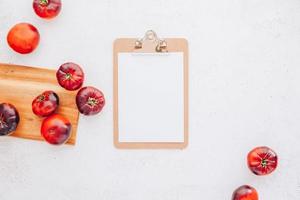 colócalo. tomates sobre fondo de mesa de madera blanca foto