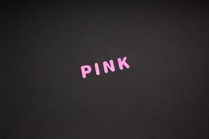 Pink writing on black paper background photo