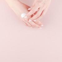 Woman moisturizing her hand with cosmetic cream photo