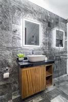 bathroom with luxury finishes, main mirror with led light from behind, white ceramic washbasin photo
