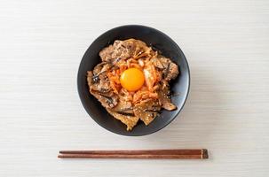 pork bulgogi rice bowl with kimchi and Korean pickled egg photo