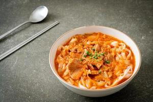 Korean udon ramen noodles with pork in kimchi soup photo