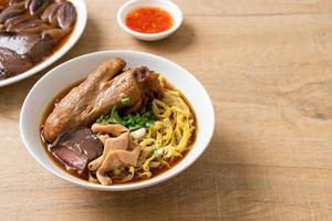 fideos de huevo con pato guisado y estofado en sopa marrón foto