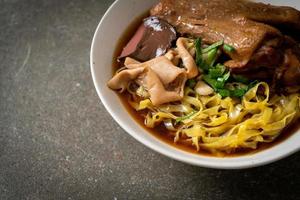 fideos de huevo con pato guisado y estofado en sopa marrón foto