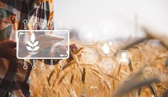 Smart farming concept. Farmer with technology digital tablet on background of wheat field. Professional farmers use internet of things IOT computers system to manage farms. agriculture modern idea. photo