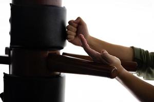 Silhouette of a fighter Wing Chun and wooden dummy on a background. Wing Chun Kung Fu Self defense photo