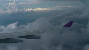 el avión desciende a través de las nubes antes de aterrizar en el aeropuerto de phuket, tailandia. vista desde el ojo de buey de la cabina video