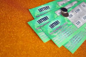 Close up view of green lottery scratch cards. Many used fake instant lottery tickets with gambling results. Gambling addiction photo