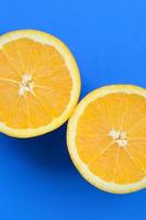 Top view of a several orange fruit slices on bright background in blue color. A saturated citrus texture image photo