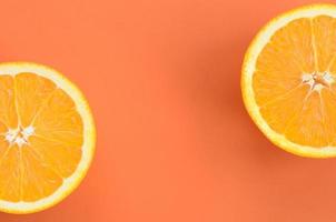 Top view of a several orange fruit slices on bright background in orange color. A saturated citrus texture image photo
