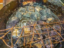 Close up Black stinky tofu Frying in the pan at fenghuang old town China.phoenix ancient town or Fenghuang County is a county of Hunan Province, China photo