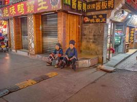 fenghuang,hunan.china-16 de octubre de 2018.personas chinas mayores desconocidas en la noche del casco antiguo de fenghuang.ciudad antigua de phoenix o fenghuang es un condado de la provincia de hunan, china foto