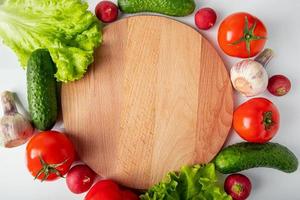 Fresh raw vegetables on a wooden cutting board. photo